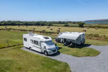Electric hardstanding pitches with field and river views