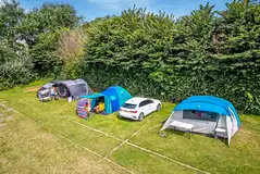 Grass pitches with optional electric hook up and space for a parked car
