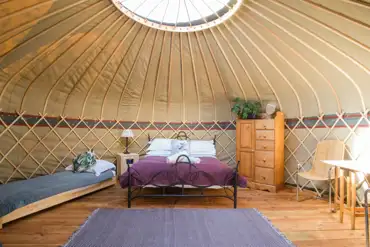Yurt interior with a king sized bed and single beds