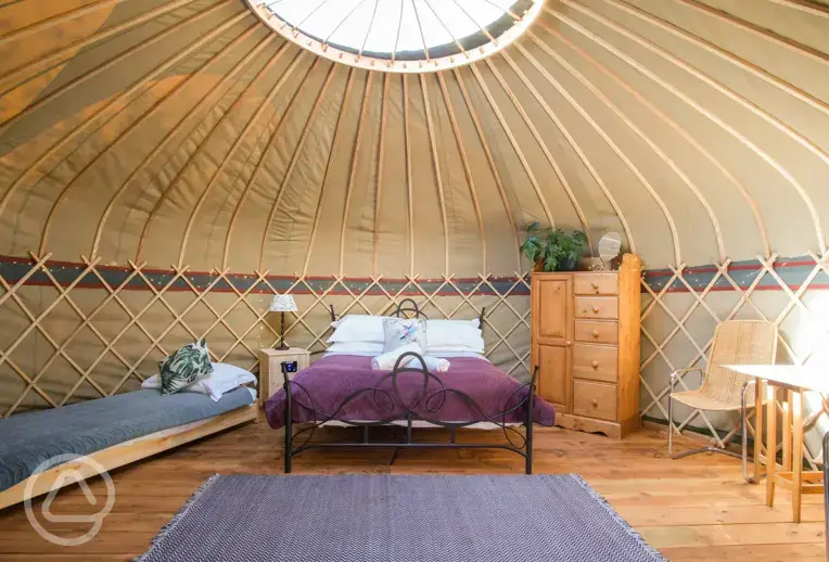 Yurt interior with a king sized bed and single beds