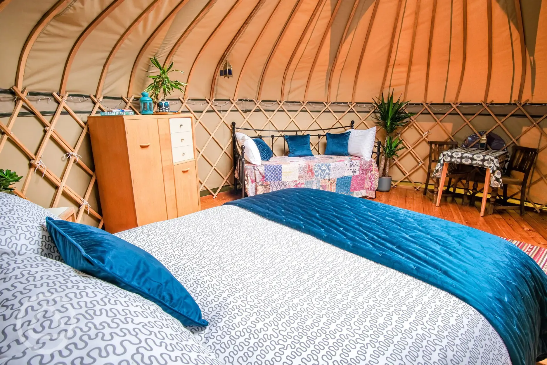 Yurt interior with a king sized bed and two single beds