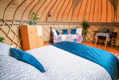 Yurt interior with a king sized bed and two single beds