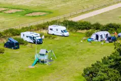 Serviced grass pitches with optional electric beside the play area