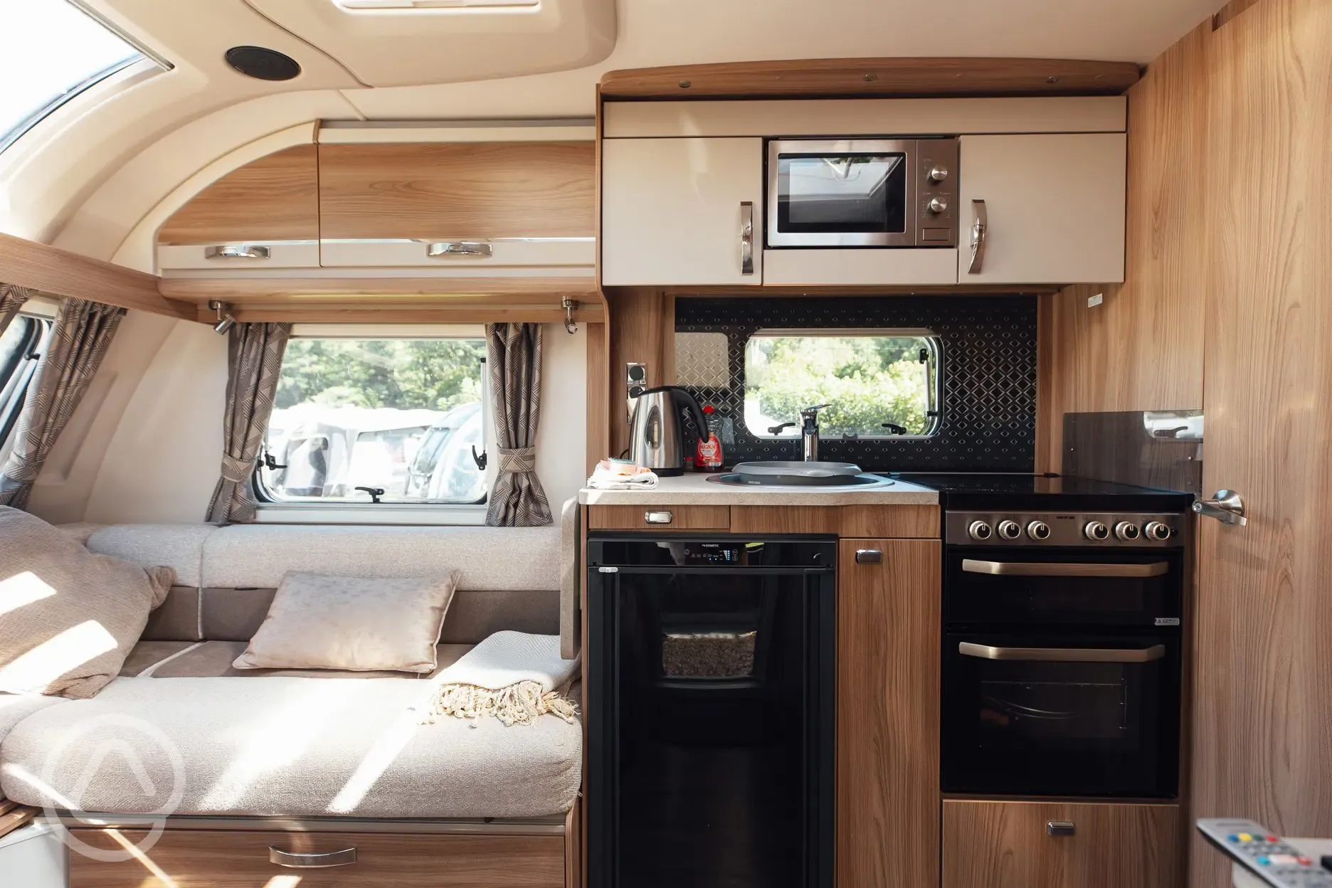 Static touring caravan for hire - kitchen and bed area