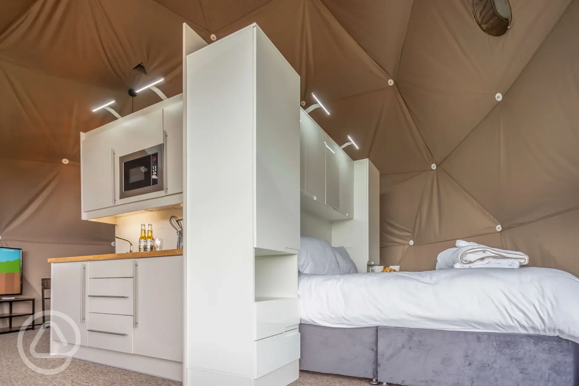 Geodome interior with a king size bed and kitchenette