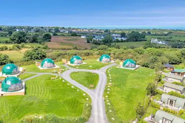 Aerial of Brynteg Glamping with the coast in the background
