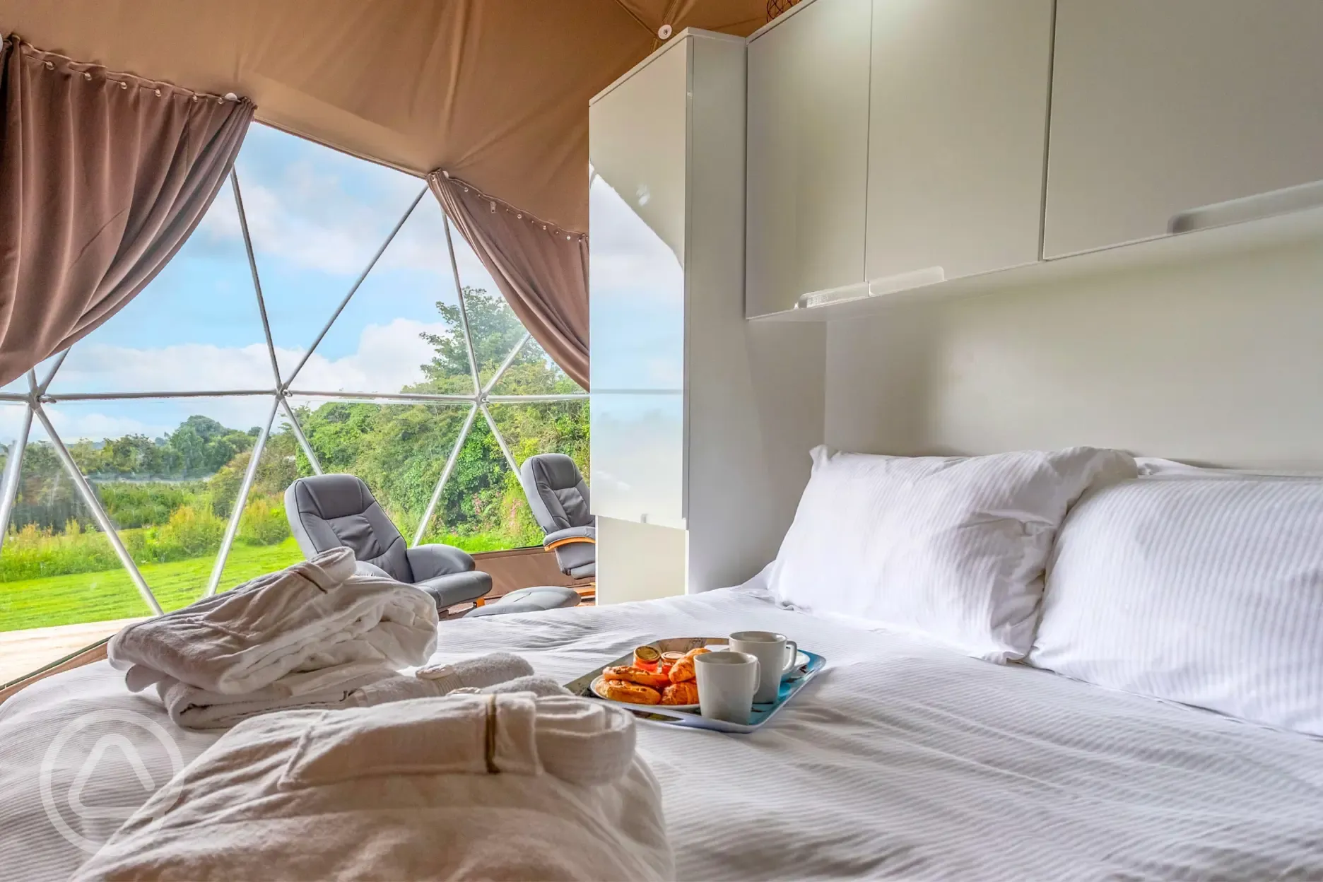 Geodome interior with a king size bed and bedding