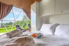 Geodome interior with a king size bed and bedding Geodome interior with a king size bed and bedding