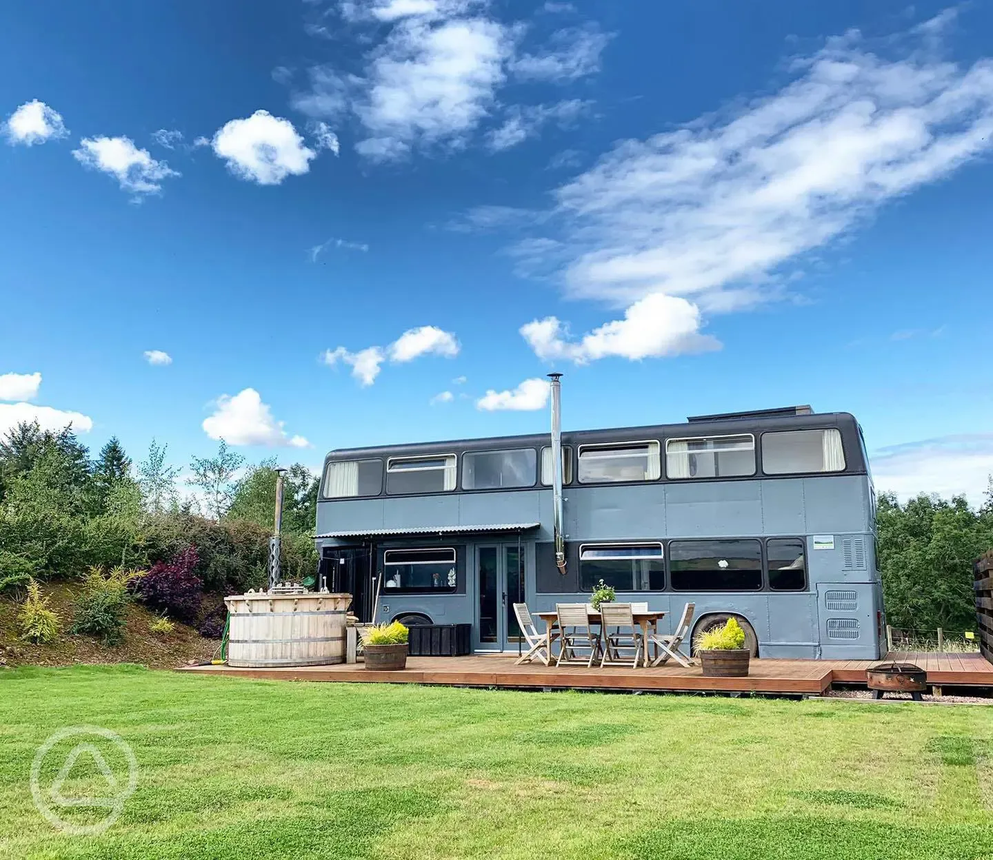 Luxury glamping bus (six person) with wood-fired hot tub and outdoor seating