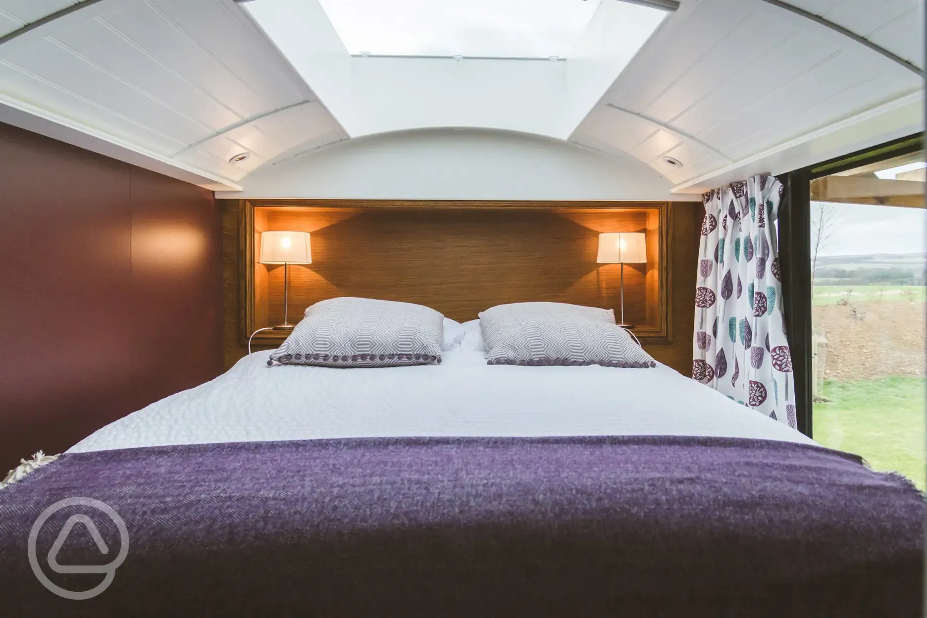 Luxury glamping bus (two person) bedroom with a king size bed and bedding 