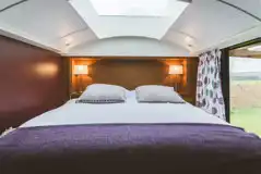 Luxury glamping bus (two person) bedroom with a king size bed and bedding 