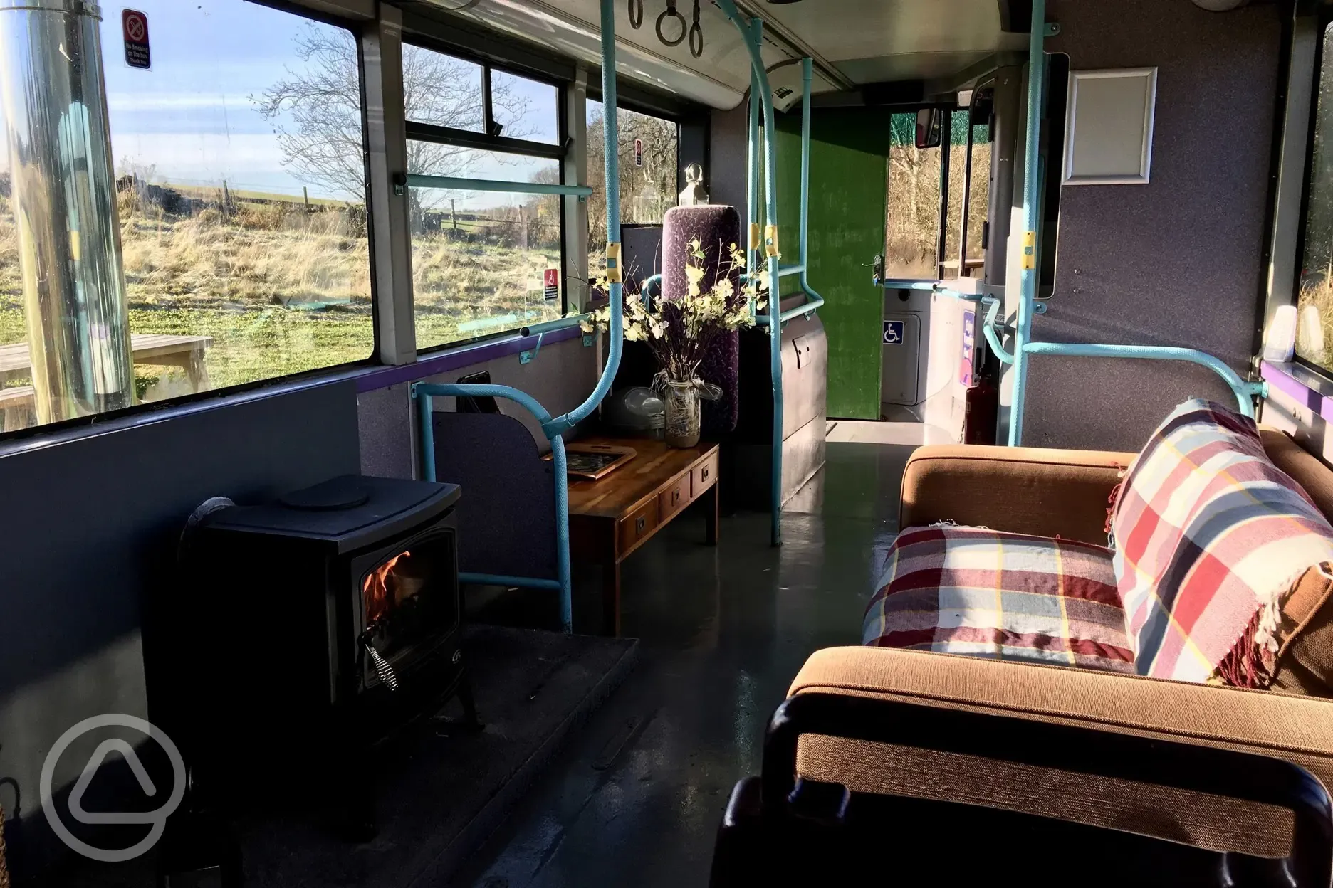 Eco bus living area with a log stove and sofa