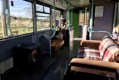 Eco bus living area with a log stove and sofa