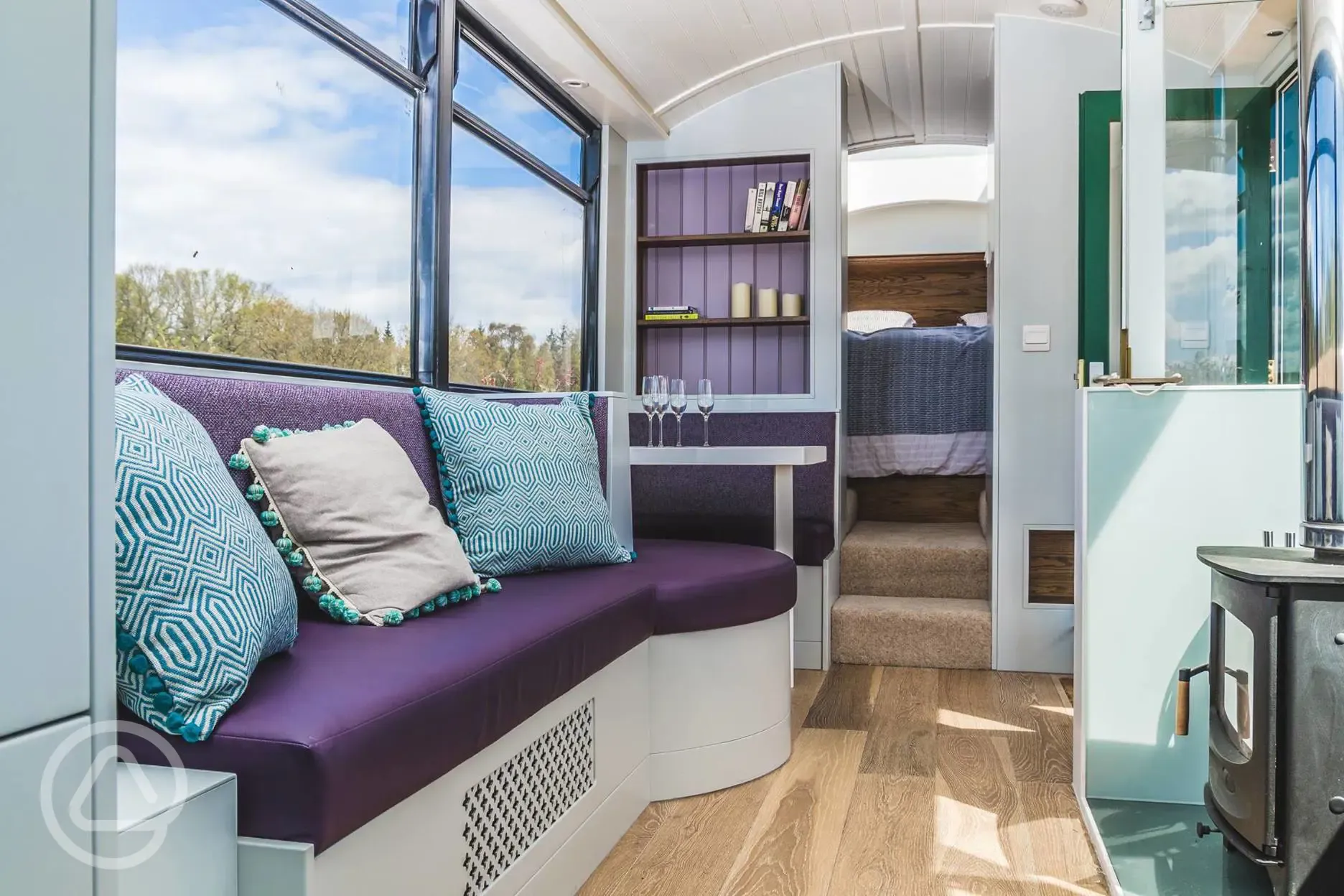 Luxury glamping bus (four person) living area with a sofa and log burner