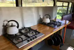 Eco bus (six person) kitchen area with hobs, kettles, and pans