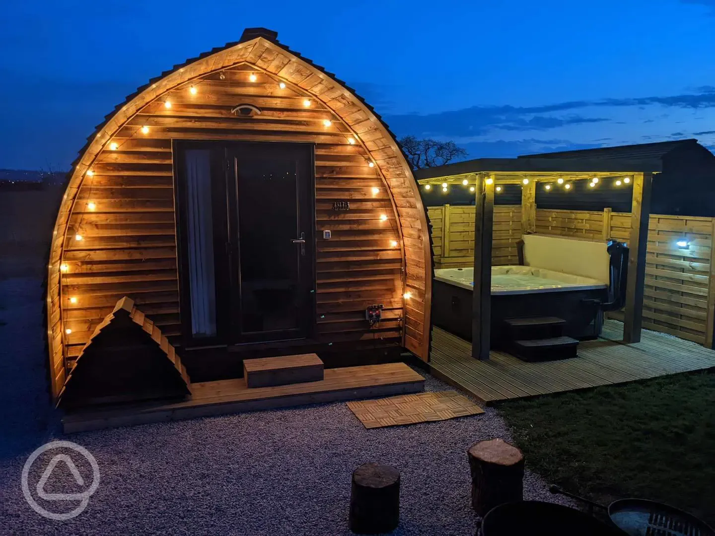 Ensuite Deluxe Wigwam Pod with electric hot tub at night