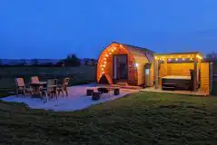 Ensuite Deluxe Wigwam Pod with electric hot tub at night