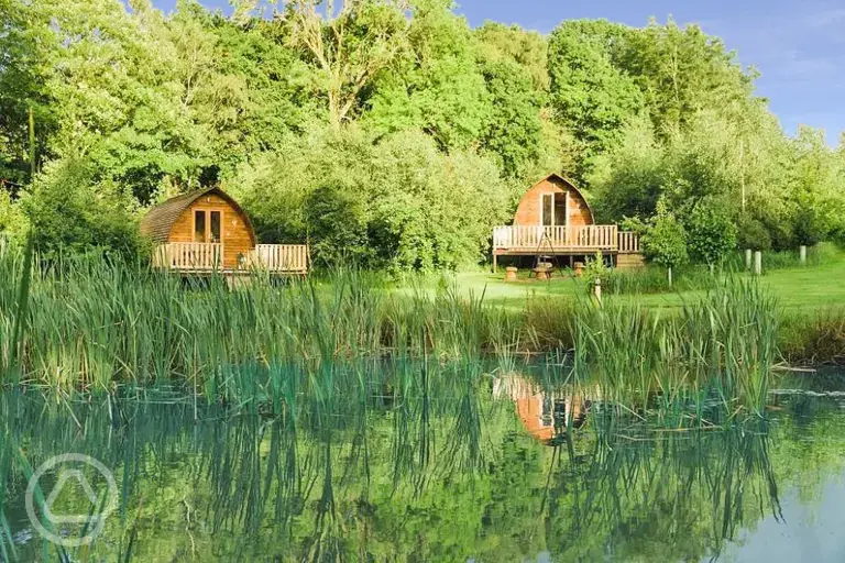 Wigwam pods with the wildlife pond