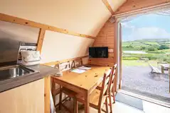 Glamping pod interior with a dining table for four and TV