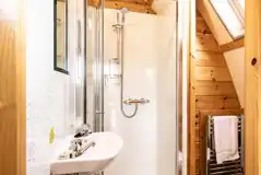 Glamping pod ensuite bathroom with a toilet, shower, sink and towel rail