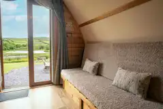 Glamping pod sofa bed with views of the lake and countryside