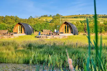 Glamping pods with views of the lake where guests can swim and kayak