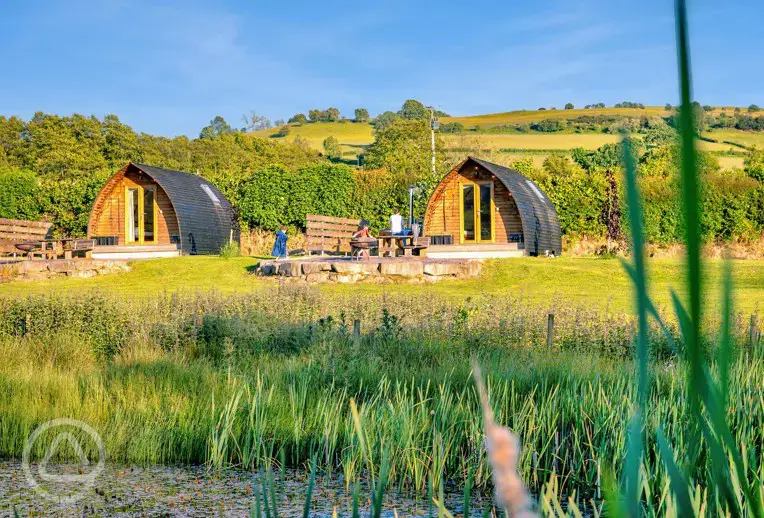 Glamping pods with views of the lake where guests can swim and kayak