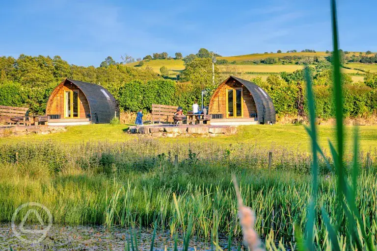 Glamping pods with views of the lake where guests can swim and kayak