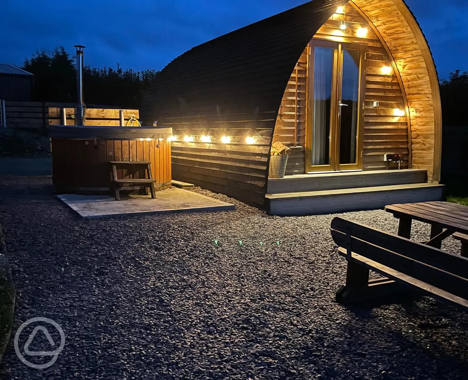 Deluxe Wigwam pod and hot tub at night