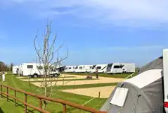 Hardstanding touring pitches with small fences to divide areas Hardstanding touring pitches with small fences to divide areas