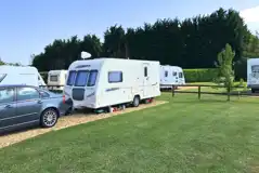 Hardstanding touring pitches with small fences to divide areas Hardstanding touring pitches with small fences to divide areas