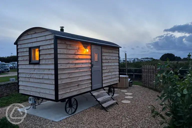 Shepherd's hut at night with outdoor wood-fired Japanese bath