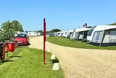 Hardstanding touring pitches with a gravel road between Hardstanding touring pitches with a gravel road between