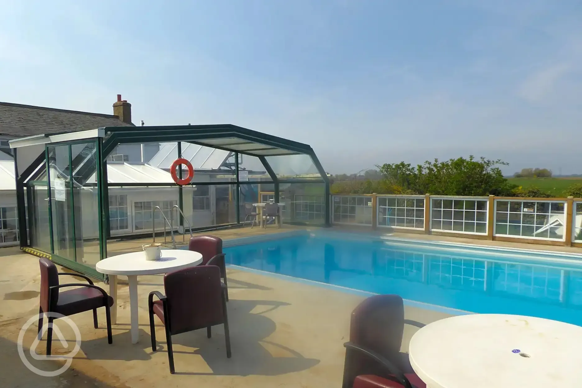 Seasonal heated outdoor swimming pool with seating and tables