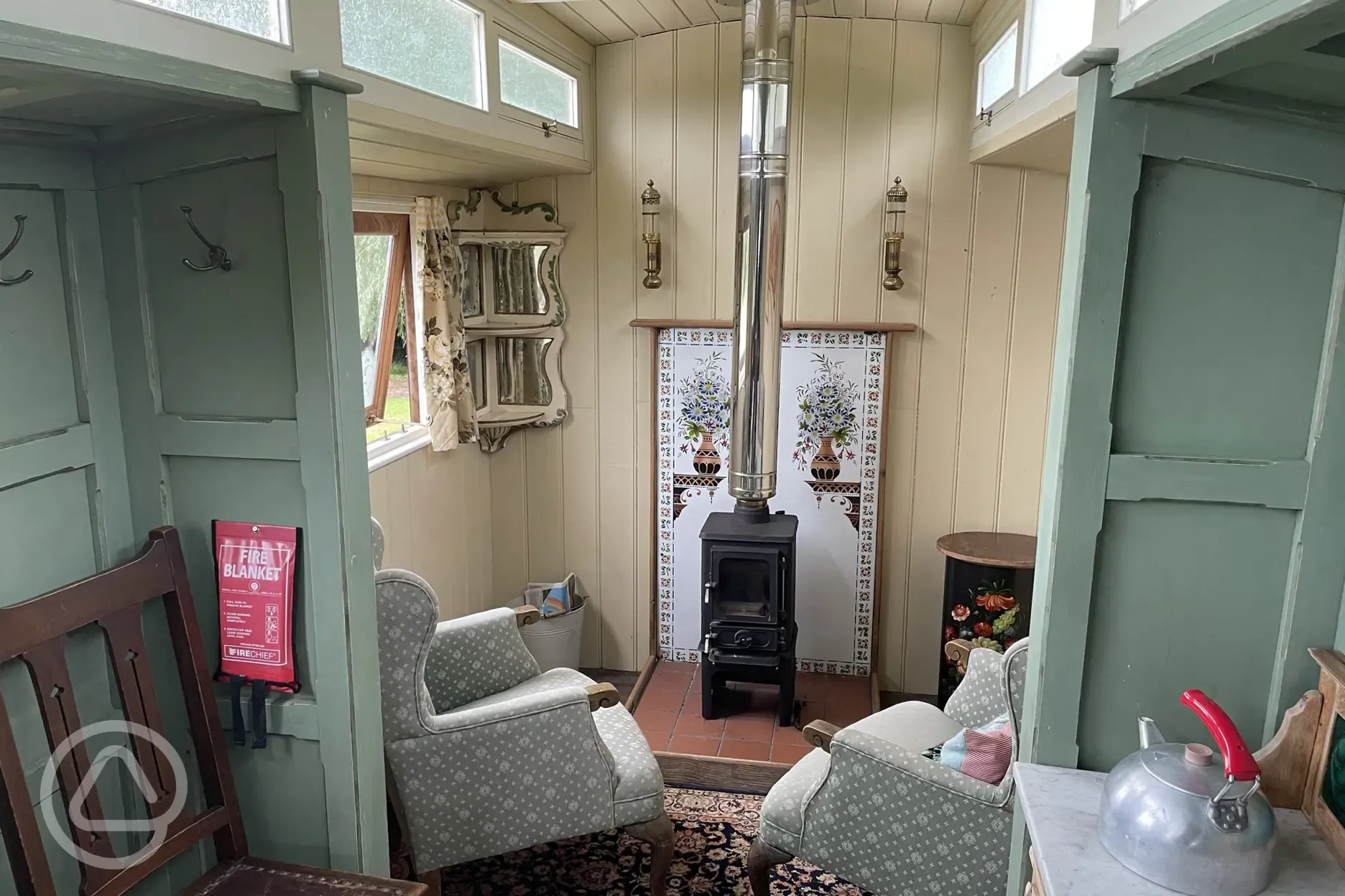 Relax by the woodburning stove in the Showman's Wagon