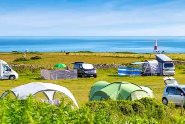 Grass pitches with views of Portland Bill Lighthouse at Sweet Hill Farm