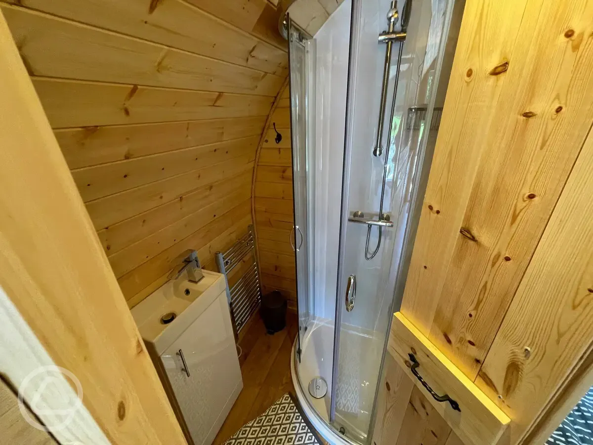 Glamping pod ensuite with a toilet, hot shower, and handwashing sink