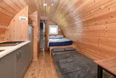 Four person glamping pod interior with a double bed and sofa bed