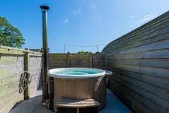 Llys y Llwynogod wood-fired hot tub with a fenced surrounding