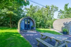 Meillion glamping pod with string lighting and outdoor seating
