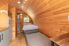Four person glamping pod interior with a double bed and sofa bed