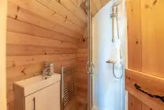 Four person pod ensuite bathroom with a toilet, shower and hand basin