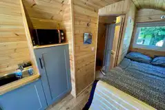 Glamping pod interior with a double bed and equipped kitchen (bedding provided) Glamping pod interior with a double bed and equipped kitchen (bedding provided)