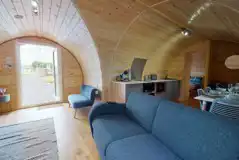 Llys Y Llwynogod pod lounge area with a sofa and kitchenette Llys Y Llwynogod pod lounge area with a sofa and kitchenette