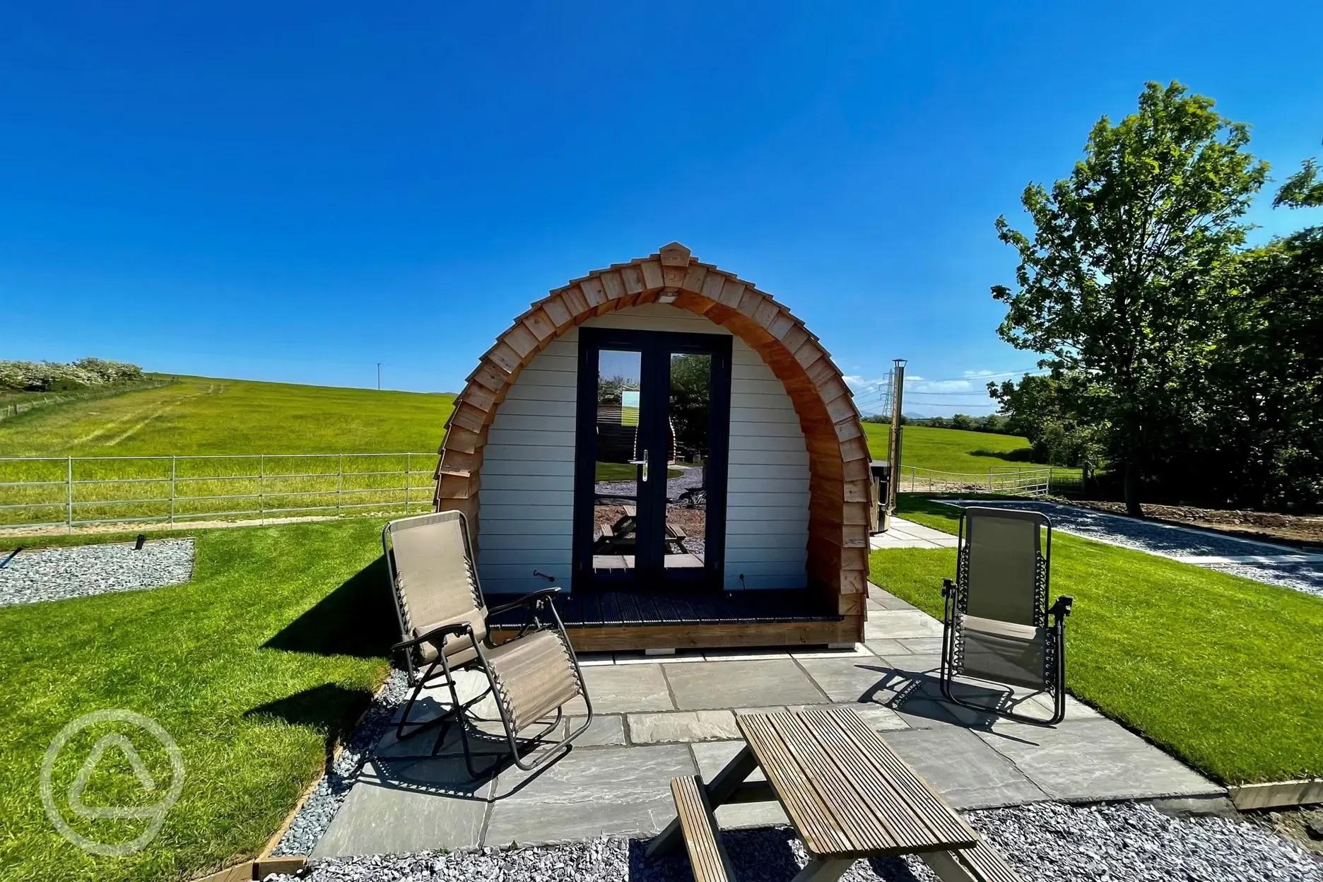 Glamping pod with a private hot tub, deck chairs, and a picnic table