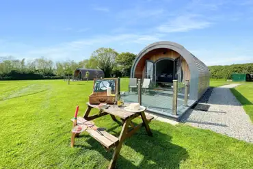 Pods with benches and private deckings at Millview Meadow Glamping