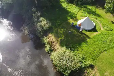 Couples pitch with bell tent by the river
