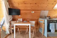 Ensuite glamping pod dining space with a wall mounted TV Ensuite glamping pod dining space with a wall mounted TV
