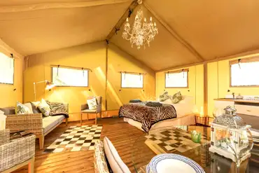 Oak safari tent open plan interior with a king size bed at Rivendell Park