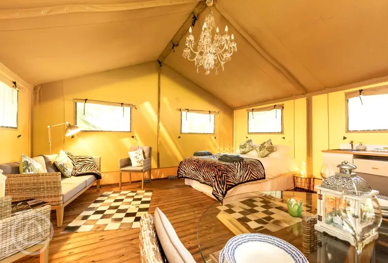 Oak safari tent open plan interior with a king size bed at Rivendell Park